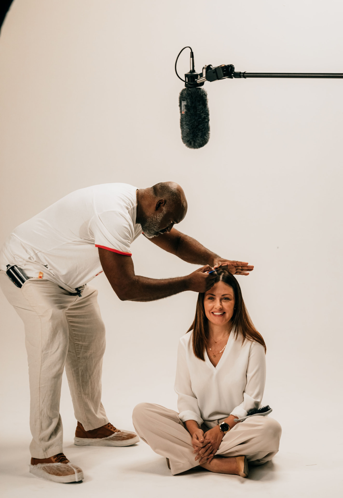Behind-the-scenes studio interview setup with boom microphone and talent preparation